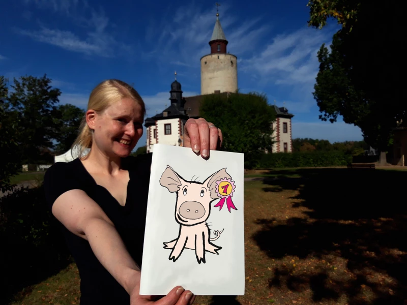 Neues Herbstferien-Rätsel auf Burg Posterstein erklärt spielerisch bäuerliche Geschichte | Franziska Huberty mit einem Bild des gesuchten Ferkels Schweinhilde