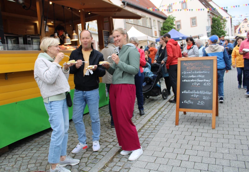 30. Kohrener Töpfermarkt – Mit vielen Gästen aus dem Altenburger Land | An einem der „Fressbuden“ schleckerte mit Wonne ein Gästetrio aus Wermsdorf um Jörg Schumann mit Schinken und Käse gefüllte Kloßteigrollen.
