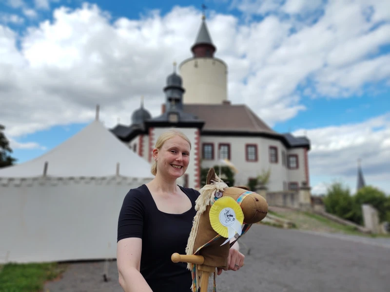 Zum achten Mal: Großes Steckenpferdturnier auf Burg Posterstein | Franziska Huberty mit einem der Postersteiner Leihpferde vor der Burg Posterstein.
